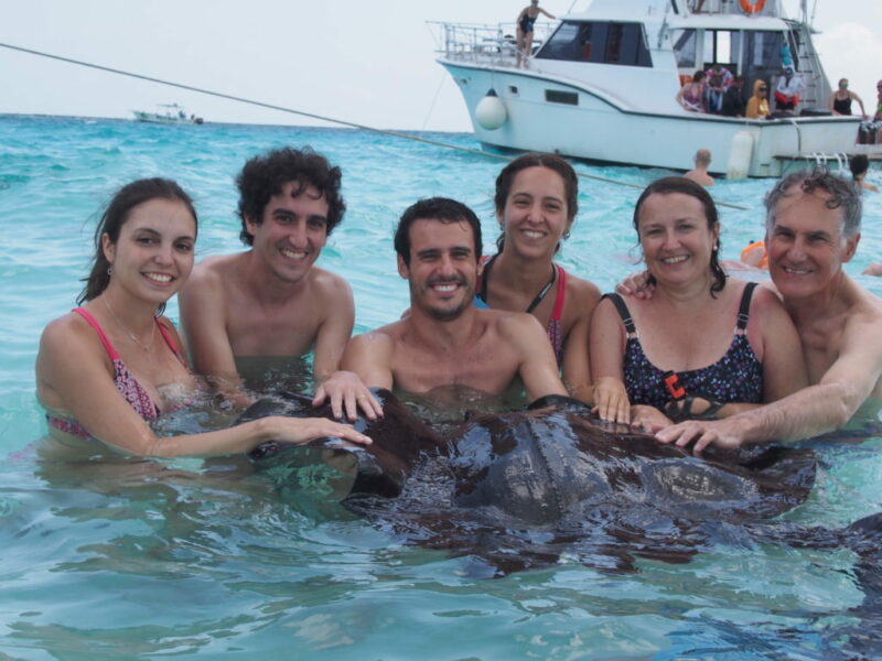 Family playing with Stingray fish at Cayman islands